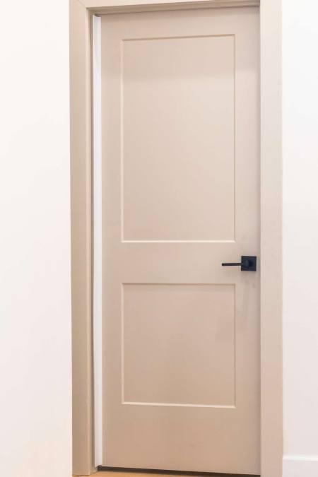 Adhesive finger pinch protector guard on a modern interior push-side door hinge.